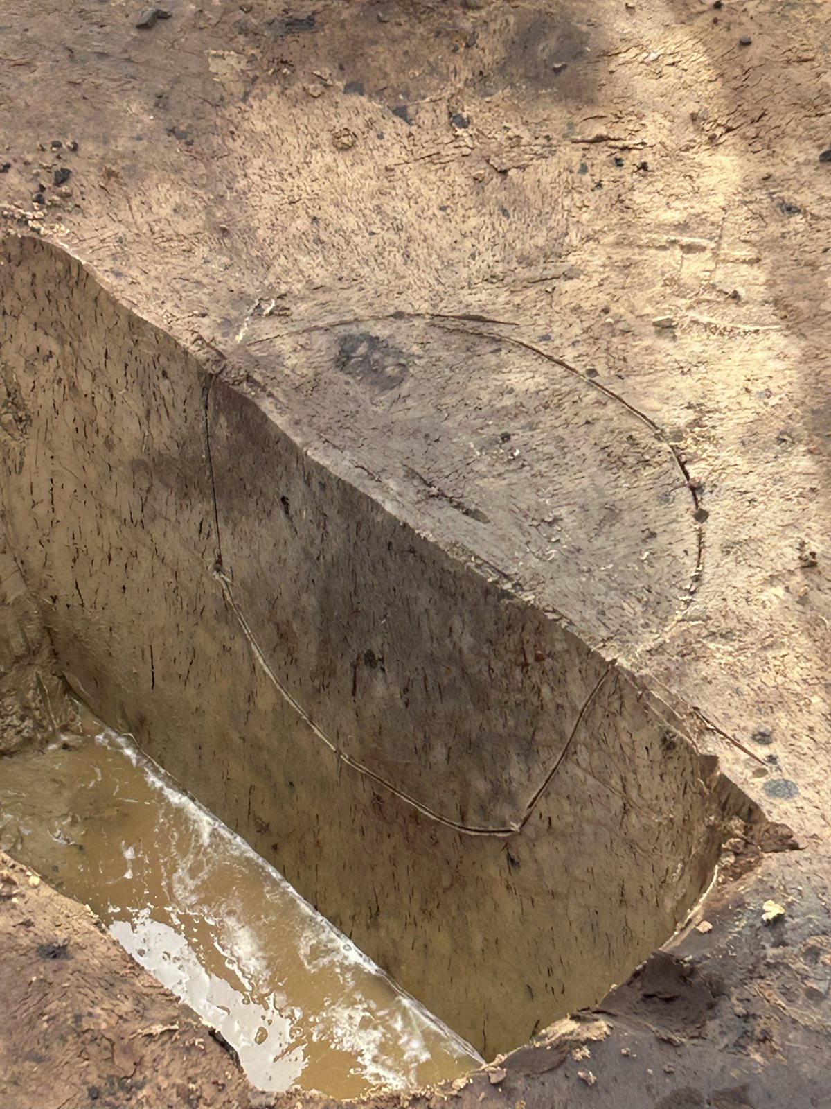 donkere plekken van de oude vuurplaats zichtbaar in de grond